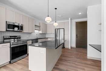 a renovated kitchen with white cabinets and black counter tops